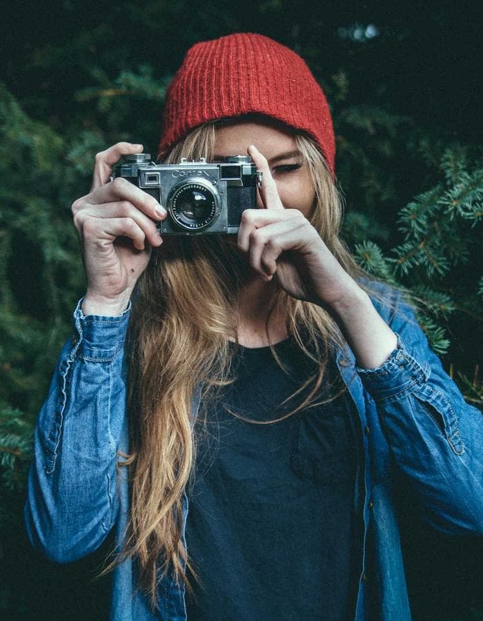 Woman photographing with a camera in a forest